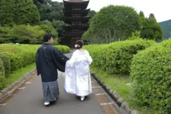 五重塔の前を手を繋いで歩くカップル